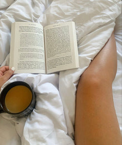 Girl reading book while drinking coffee